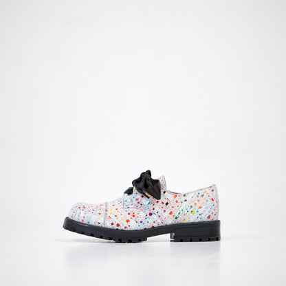 White leather military-grade boots with colorful splatter design and a black bow, by Samelin.