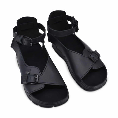 Black handmade leather sandals with adjustable ankle straps and anatomical support by Omaking.