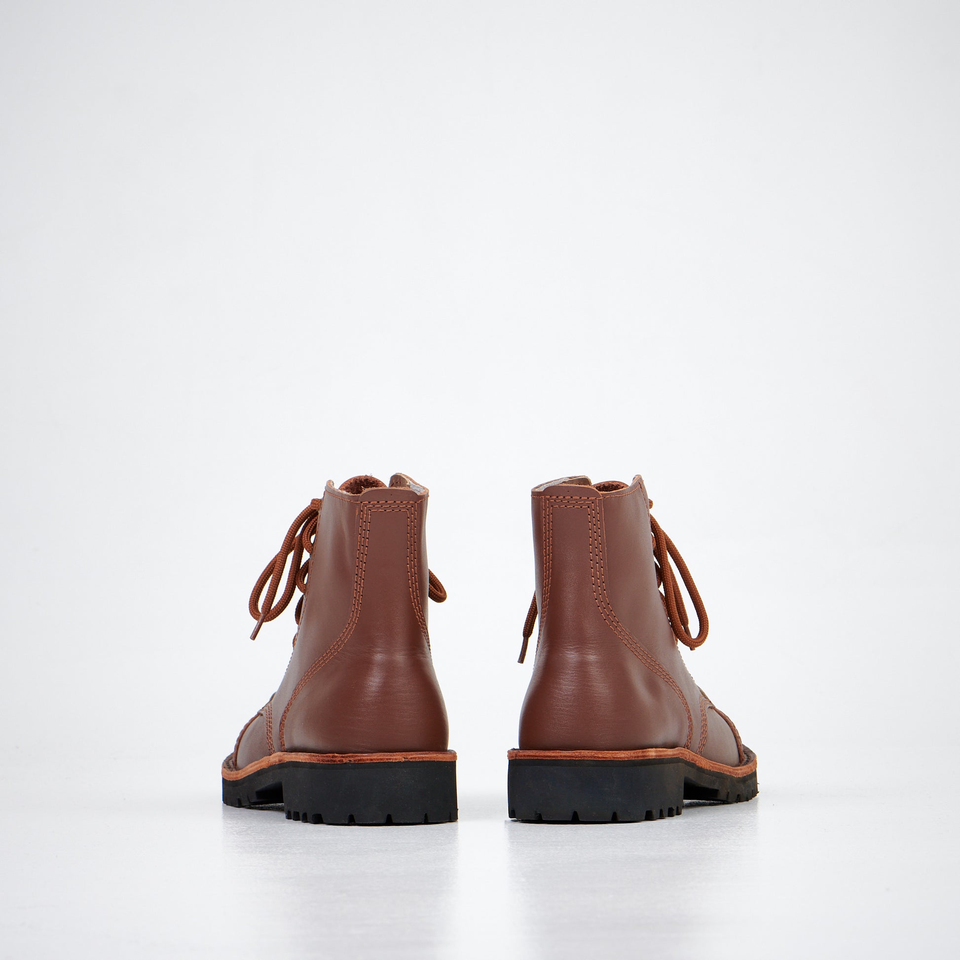 Brown leather ankle boots with lace-up design and rugged sole, by AIPI, available in multiple sizes.